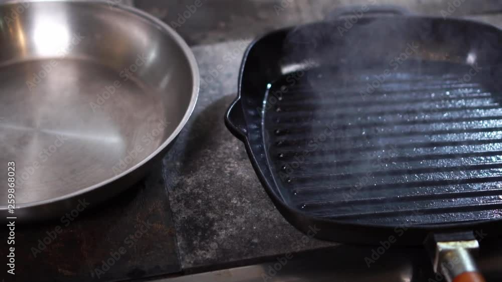 Close up view on hot steam coming up from black grill frying pan in slow motion Close up view on hot steam coming up from black grill frying pan in slow motion