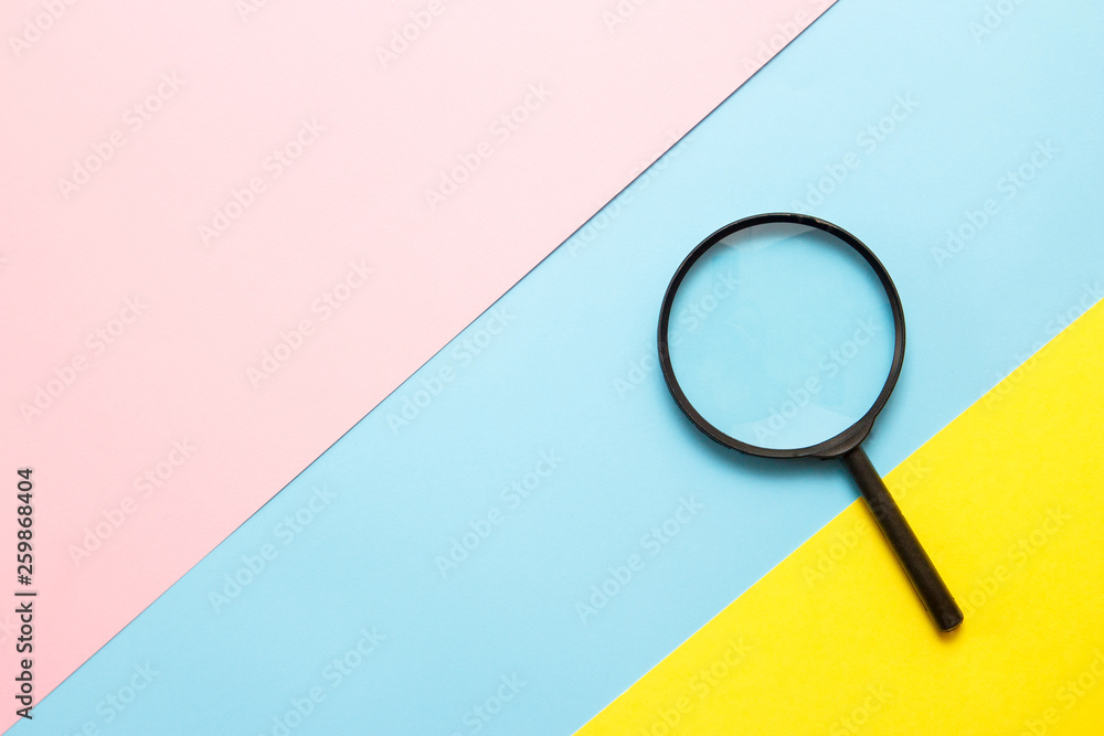 Magnifier on colored paper. Top view. Search concept Magnifier on colored paper. Top view. Search concept