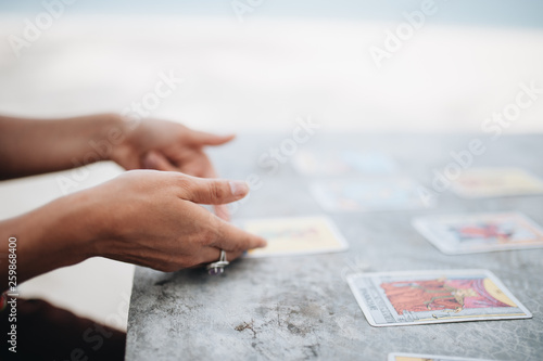 Woman is reading Tarot cards at the beach