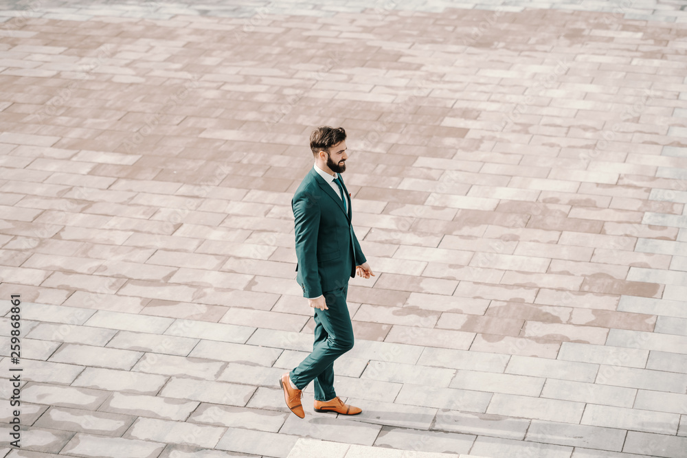 Successful Caucasian bearded businessman in formal wear walking on the rooftop. Create a vision that makes you wanna jump out of bed in the morning. Successful Caucasian bearded businessman in formal wear walking on the rooftop. Create a vision that makes you wanna jump out of bed in the morning.