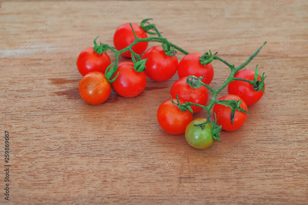 Small Tomato on wood background.Food concept. Small Tomato on wood background.Food concept.