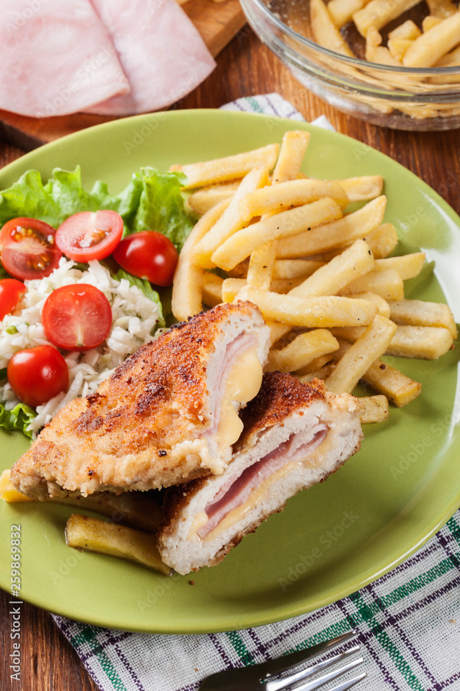 Cutlet Cordon Bleu with pork loin served with French fries and s Cutlet Cordon Bleu with pork loin served with French fries and s