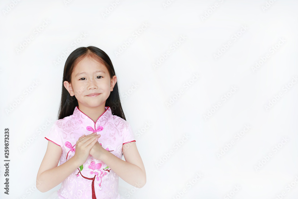 Smiling little Asian child girl wearing pink traditional chinese dress with greeting gesture celebration for Chinese New Year isolated on white background. Smiling little Asian child girl wearing pink traditional chinese dress with greeting gesture celebration for Chinese New Year isolated on white background.