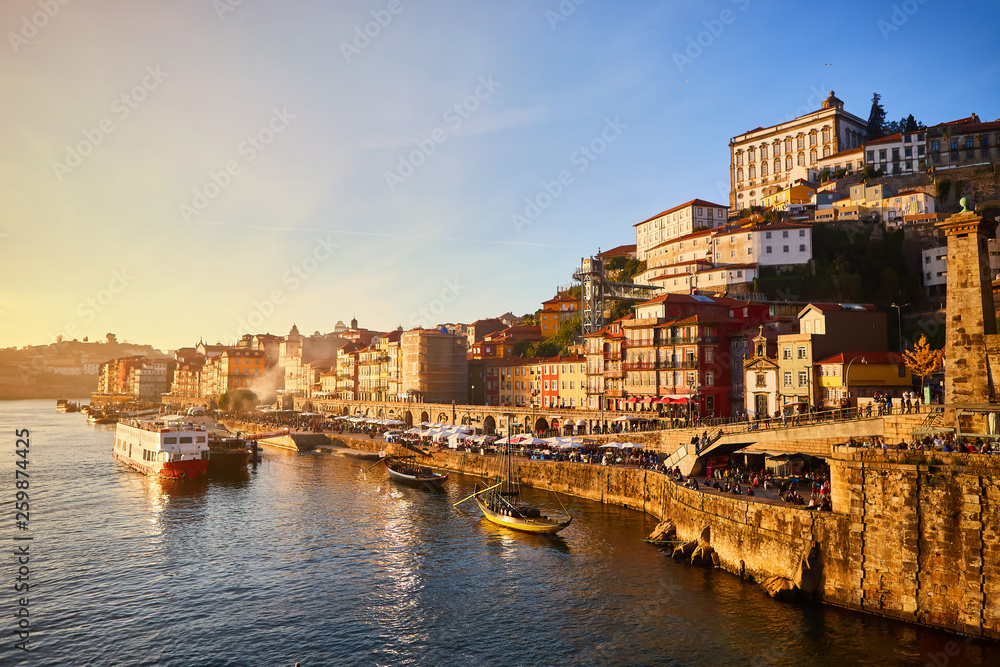 Fototapeta premium Portugalia, widok na promenadę Ribeira na starym mieście w Porto z kolorowymi domami, rzeką Douro i łodziami.