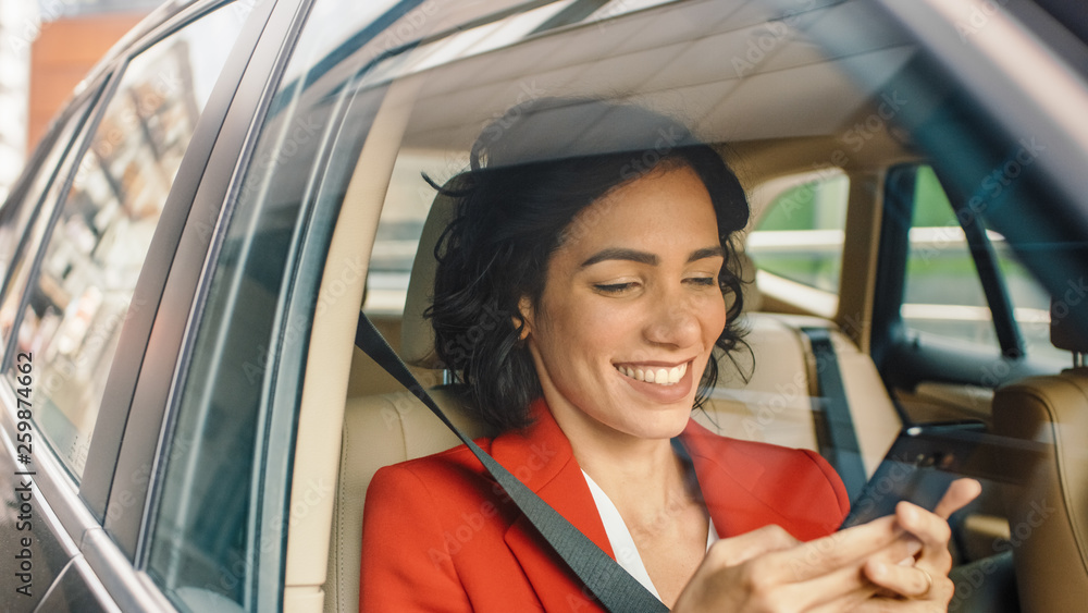 Beautiful Woman Traveling in a Car, Sitting on a Passenger Seat Uses Smartphone, types Message, Browses Through Internet. Camera Shot from Outside the Vehicle. Beautiful Woman Traveling in a Car, Sitting on a Passenger Seat Uses Smartphone, types Message, Browses Through Internet. Camera Shot from Outside the Vehicle.