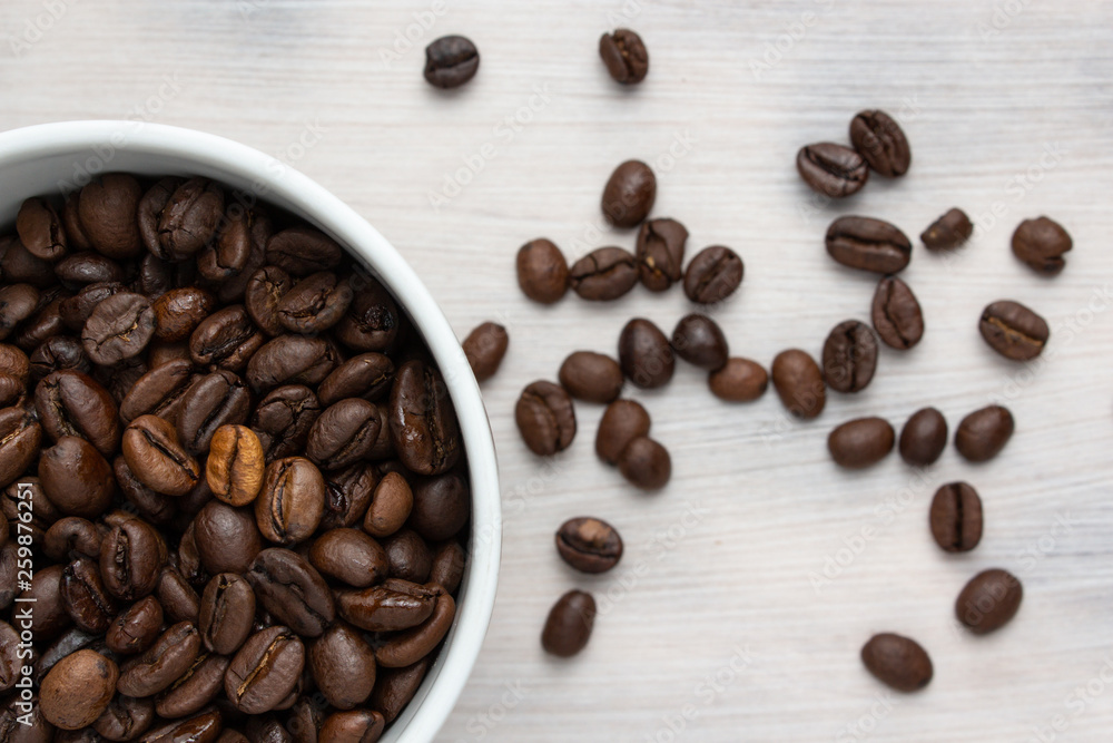 Coffee beans in a white cup on a white background. Coffee beans in a white cup on a white background.