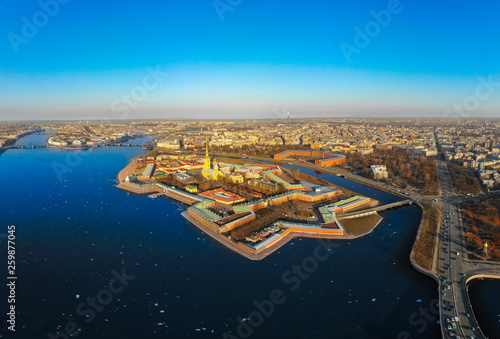 Beautifull aerial view of the Petropavlovsky fortress in sunny spring day. Golden tall spire of famous Peter and Paul Cathedral on the blue sky background. Historical centre of St. Petersburg  Russia.