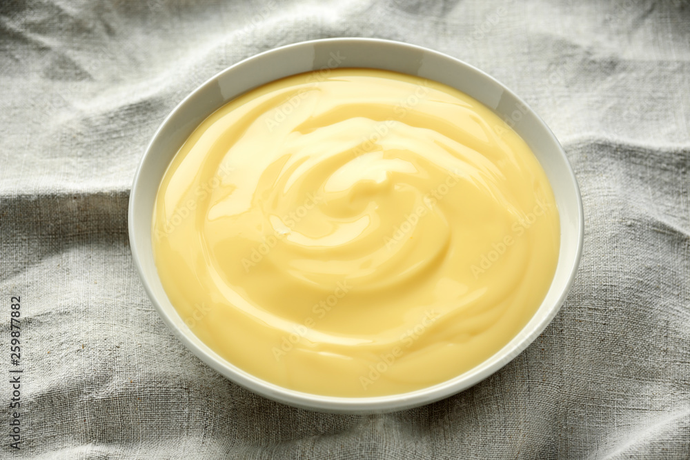 Bowl of vanilla custard on rustic background Bowl of vanilla custard on rustic background