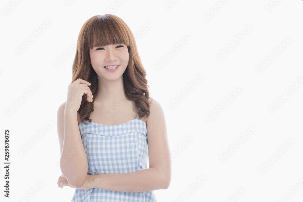 Front view close-up portrait of young beautiful Asian woman with curly long dark brown hair in light blue checked dress stand up straight isolated white background Front view close-up portrait of young beautiful Asian woman with curly long dark brown hair in light blue checked dress stand up straight isolated white background