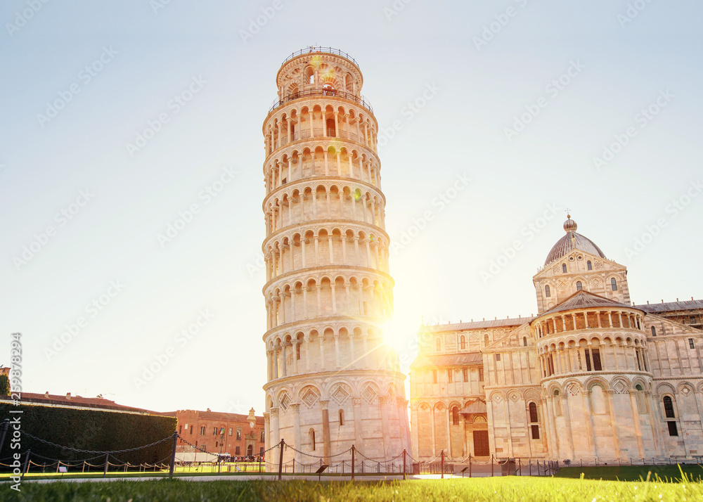 Pisa leaning tower and cathedral basilica at sunrise, Italy. Travel concept