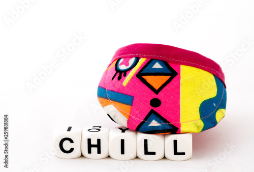 The term chill in black text together with a colorful sun visor cap isolated on a white background image with copy space in landscape format photo