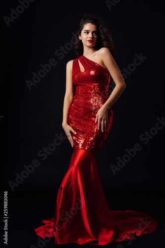 Fashion Model in Red Dress, Beautiful Woman. Full length portrait of young sexy woman in red dress Fashionable shoot of beautiful stunning lady on black background © Tetiana Moish