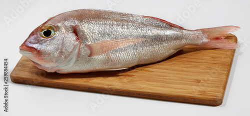 Fresh red sea bream fish on wooden cutting board