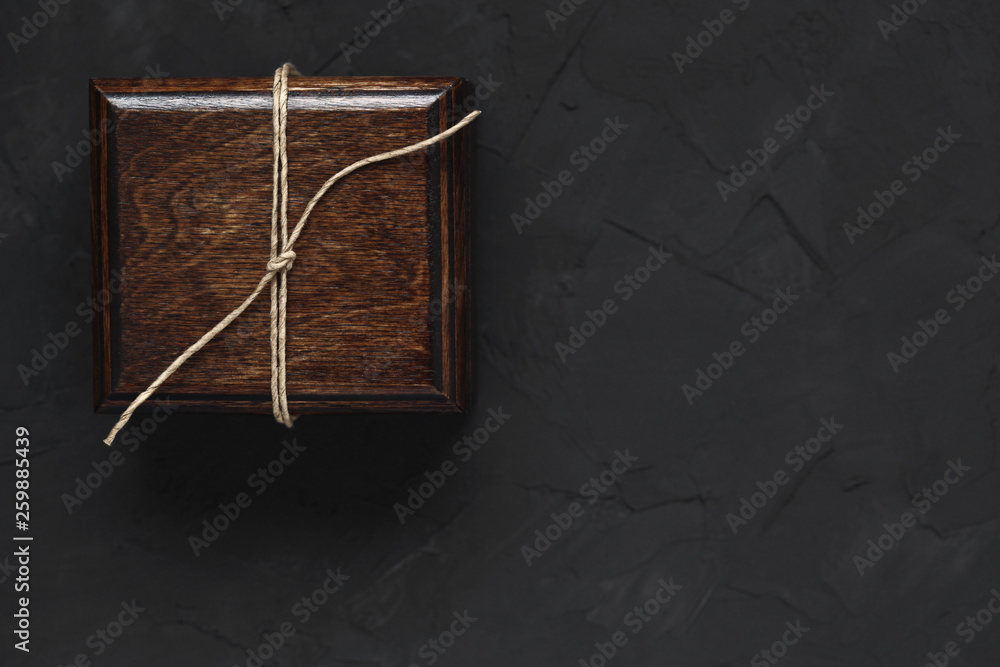 Fototapeta premium Wooden box gift. Black decorative concrete background. Lots of free space