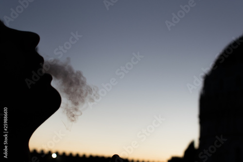 silhouette of a man smoking in the sunset