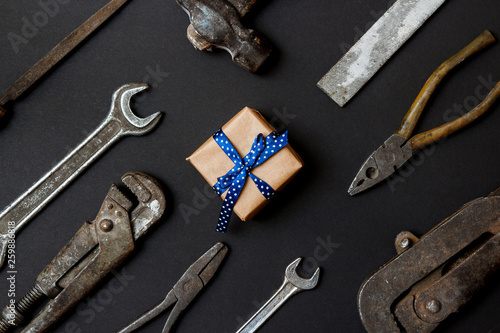 Craft gift with vintage old tools on black paper background. Fathers day concept. Flat lay