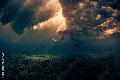Surfer dives under the breaking wave