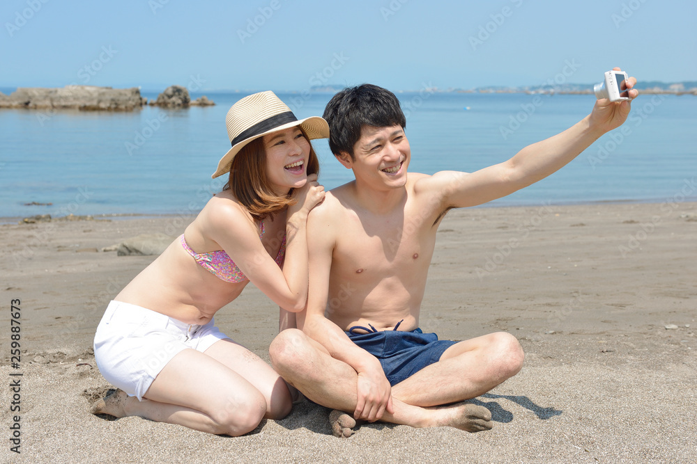 ビーチで自撮りするカップル