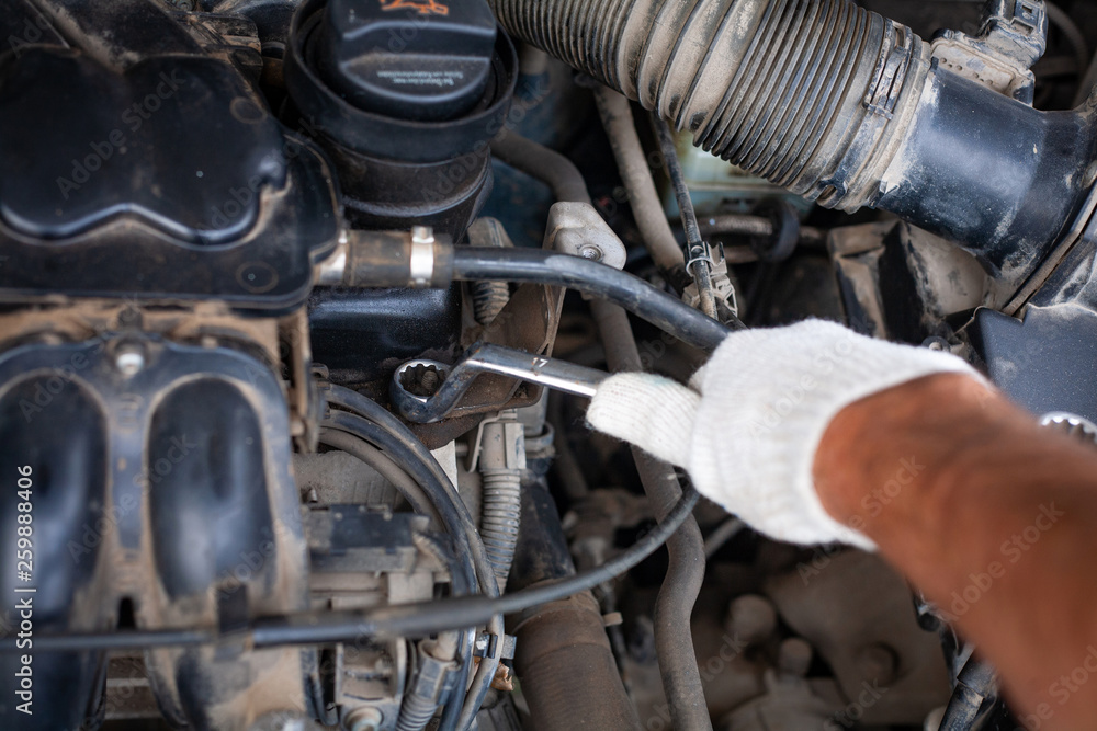 Fototapeta premium mechanic men with wrench repairing car engine at