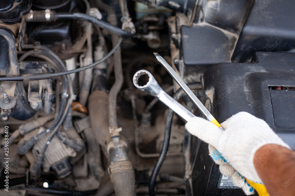mechanic men with wrench repairing car engine at mechanic men with wrench repairing car engine at