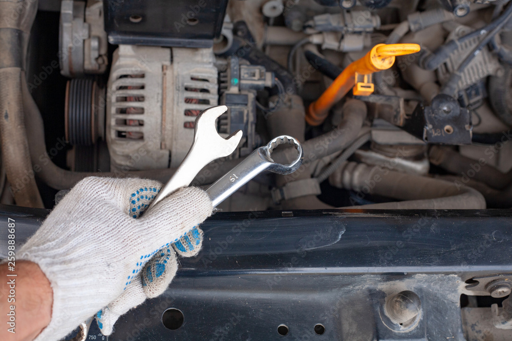 mechanic men with wrench repairing car engine at