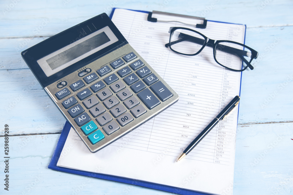 document with glasses and calculator on desk document with glasses and calculator on desk
