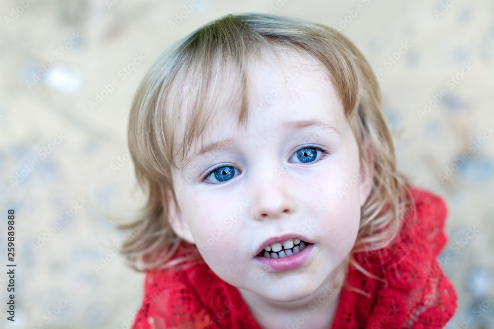 cute two years old blonde white girl face closeup top view on outdoor background cute two years old blonde white girl face closeup top view on outdoor background