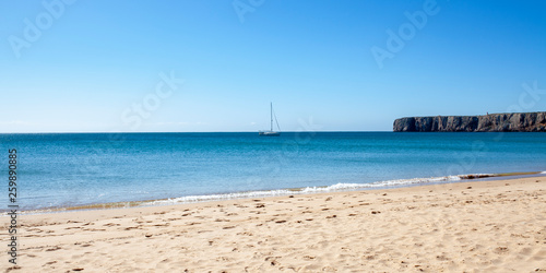 Velero fondeado junto a la playa de Sagres, Algarve (Portugal) photo