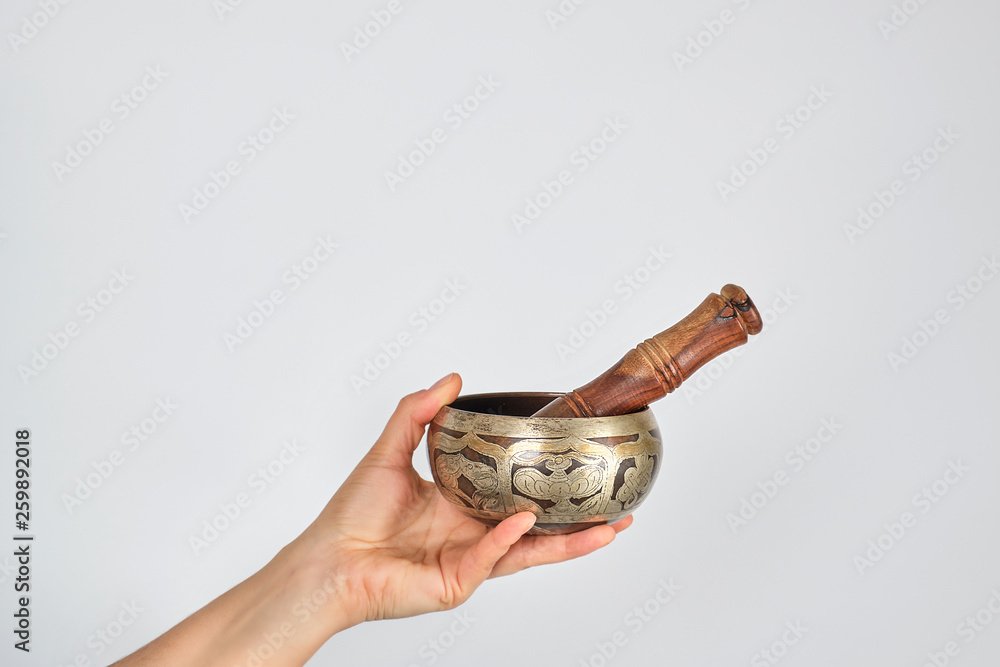 copper singing bowl and wooden stick in female hand copper singing bowl and wooden stick in female hand