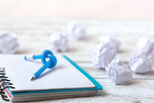 Slika na platnu Blue Pencil with knot on writing pad on white wood background