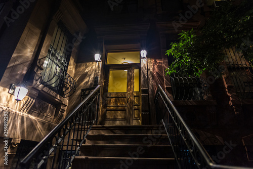 Old typical houses at night in Harlem, in New York City, USA