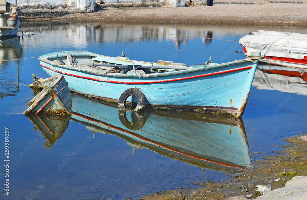 old wooden fishing boat reflected on water at a small lake pond Alimos  Greece Stock Photo
