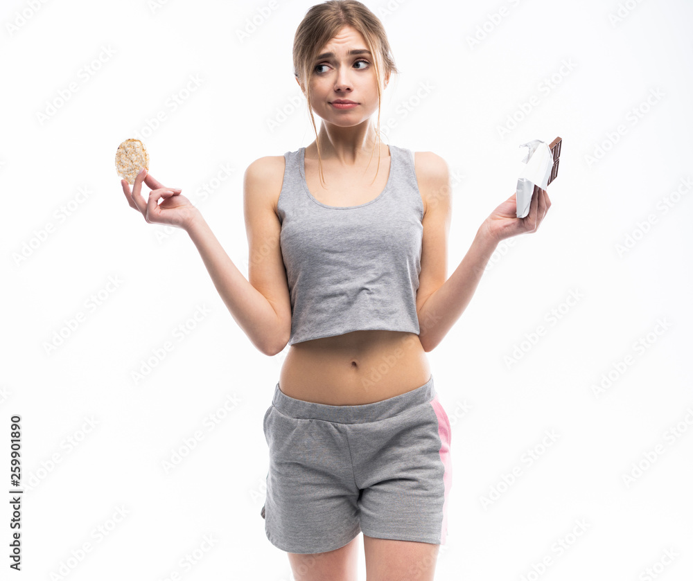 Diet. Dieting concept. Healthy Food. Beautiful Young Woman choosing between Healthy and Unhealthy Food.Fruits or Sweets. Isolated on a White Diet. Dieting concept. Healthy Food. Beautiful Young Woman choosing between Healthy and Unhealthy Food.Fruits or Sweets. Isolated on a White