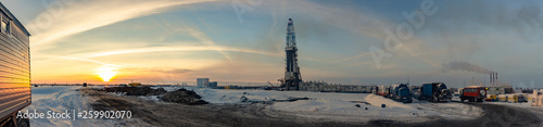 drilling rig on land in winter in the cold against the sunset and the beautiful sky panorama