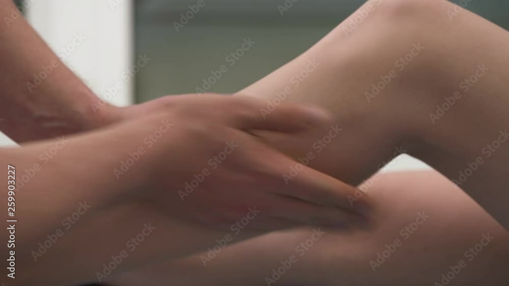 A physiotherapist massaging the calf muscle of a patient. Physiotherapy and rehabilitation, kinesio therapy A physiotherapist massaging the calf muscle of a patient. Physiotherapy and rehabilitation, kinesio therapy
