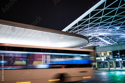 Tilburg, Noord Brabant, Netherlands - april 2 2019: A bus driving next to the bus station and train station. This is the new public transport hub in Tilburg. Seen at night.