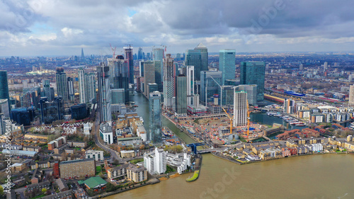 Aerial drone shot from iconic Canary Wharf skyscraper business and financial area with lots of clouds, Docklands, Isle of Dogs, London, United Kingdom © aerial-drone