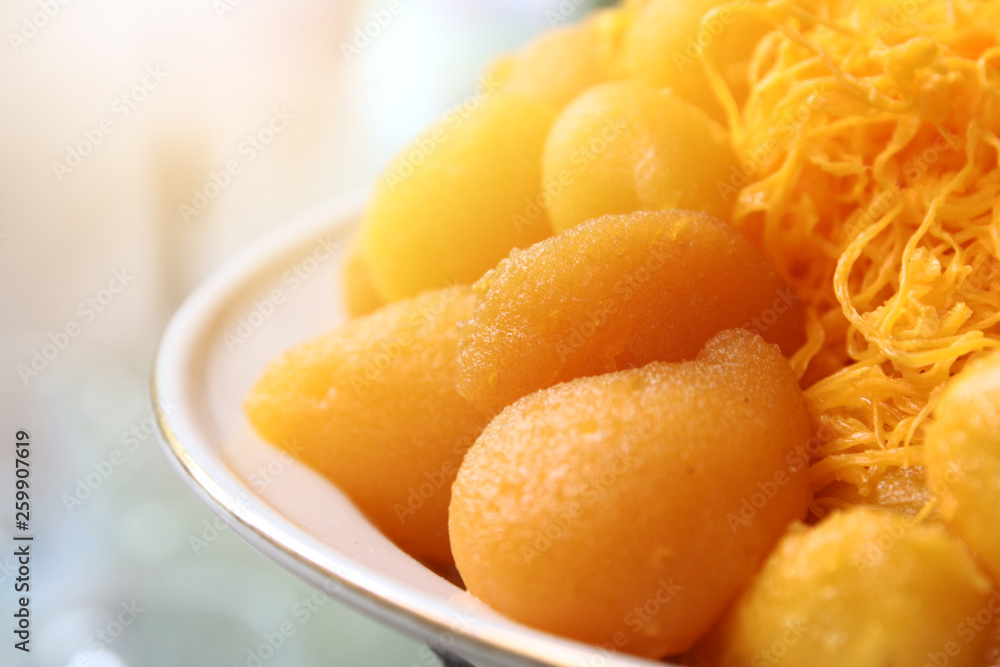 Culture of Thai sweet Dessert egg yoke fudge balls cooked in syrup, bean-paste and golden threads on white plate. Culture of Thai sweet Dessert egg yoke fudge balls cooked in syrup, bean-paste and golden threads on white plate.