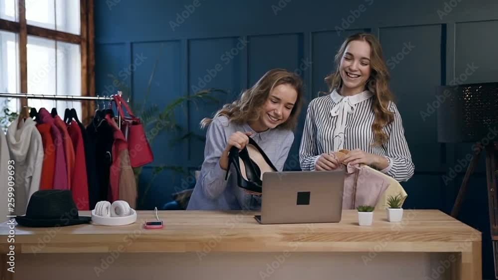Two female friends giving advice how to choose clothes during shooting video blog about fashion style. Two female friends giving advice how to choose clothes during shooting video blog about fashion style.
