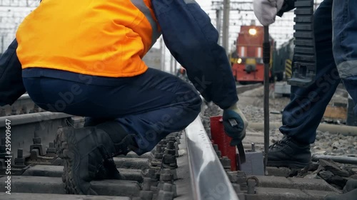 Repairmen on railway tracks. Railway workers stands on freight station and repair the railway 