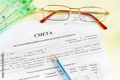 Document in Russian "Estimates for finishing works and materials used ", glasses, money and a pen on the table