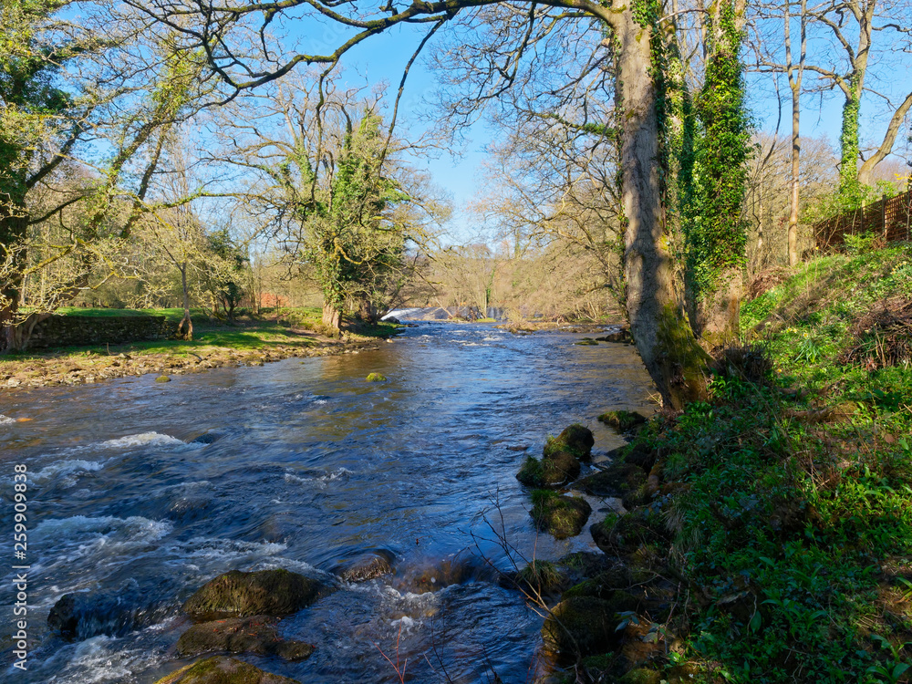 River Derwent flowing from a distant Calver Weir in the Derbyshire Peak District River Derwent flowing from a distant Calver Weir in the Derbyshire Peak District
