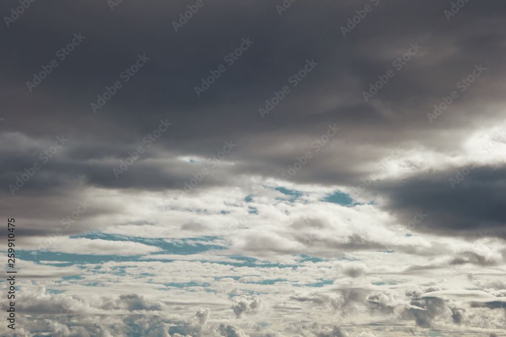 layers of grey and white clouds over blue sky