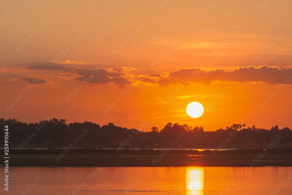 Sunset in the lake. beautiful sunset behind the clouds above the over lake landscape background. dramatic sky with cloud at sunset Sunset in the lake. beautiful sunset behind the clouds above the over lake landscape background. dramatic sky with cloud at sunset