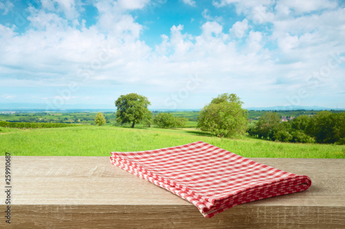 Fototapeta Naklejka Na Ścianę i Meble -  Empty wooden table with tablecloth over summer meadow background