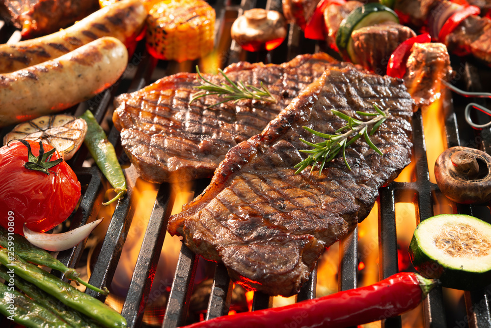 Delicious grilled meat with vegetables sizzling over the coals on barbecue - obrazy, fototapety, plakaty 