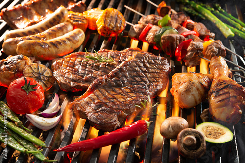 Obraz na płótnie Delicious grilled meat with vegetables sizzling over the coals on barbecue