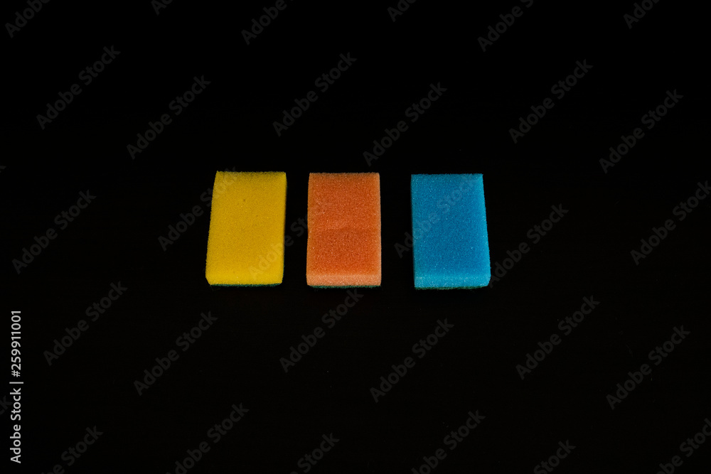 Three multicolor sponges on a black background. Isolated Three multicolor sponges on a black background. Isolated