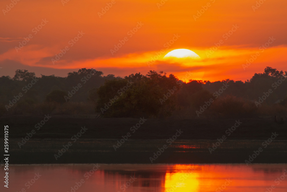 Sunset in the lake. beautiful sunset behind the clouds above the over lake landscape background. dramatic sky with cloud at sunset Sunset in the lake. beautiful sunset behind the clouds above the over lake landscape background. dramatic sky with cloud at sunset