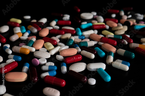 Multicolor pills and capsules on a black table